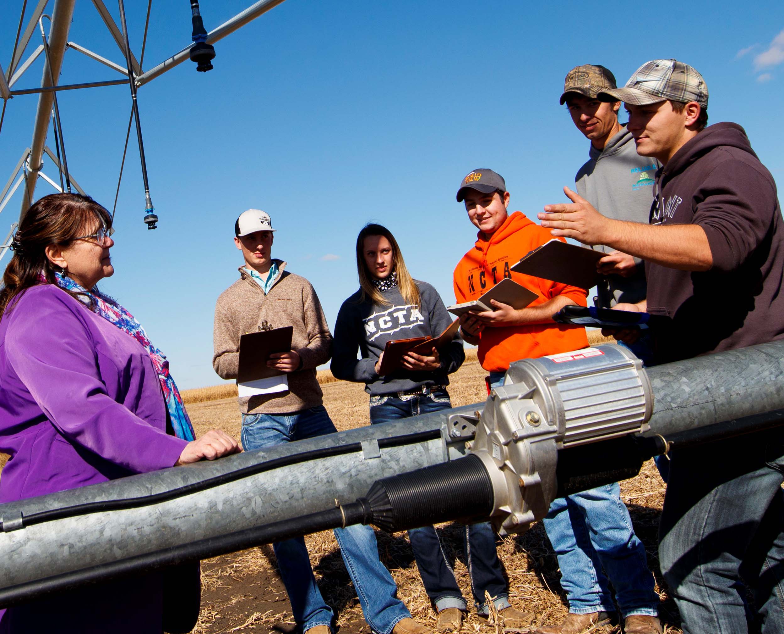 Mary Rittenhouse, Agri Business Management professor, visits with students about costs of production at the NCTA Farm. For high school students in dual credit, she teaches two online classes, Introduction to Ag Economics and Principles of Microeconomics. (Chandler/NCTA Photo)