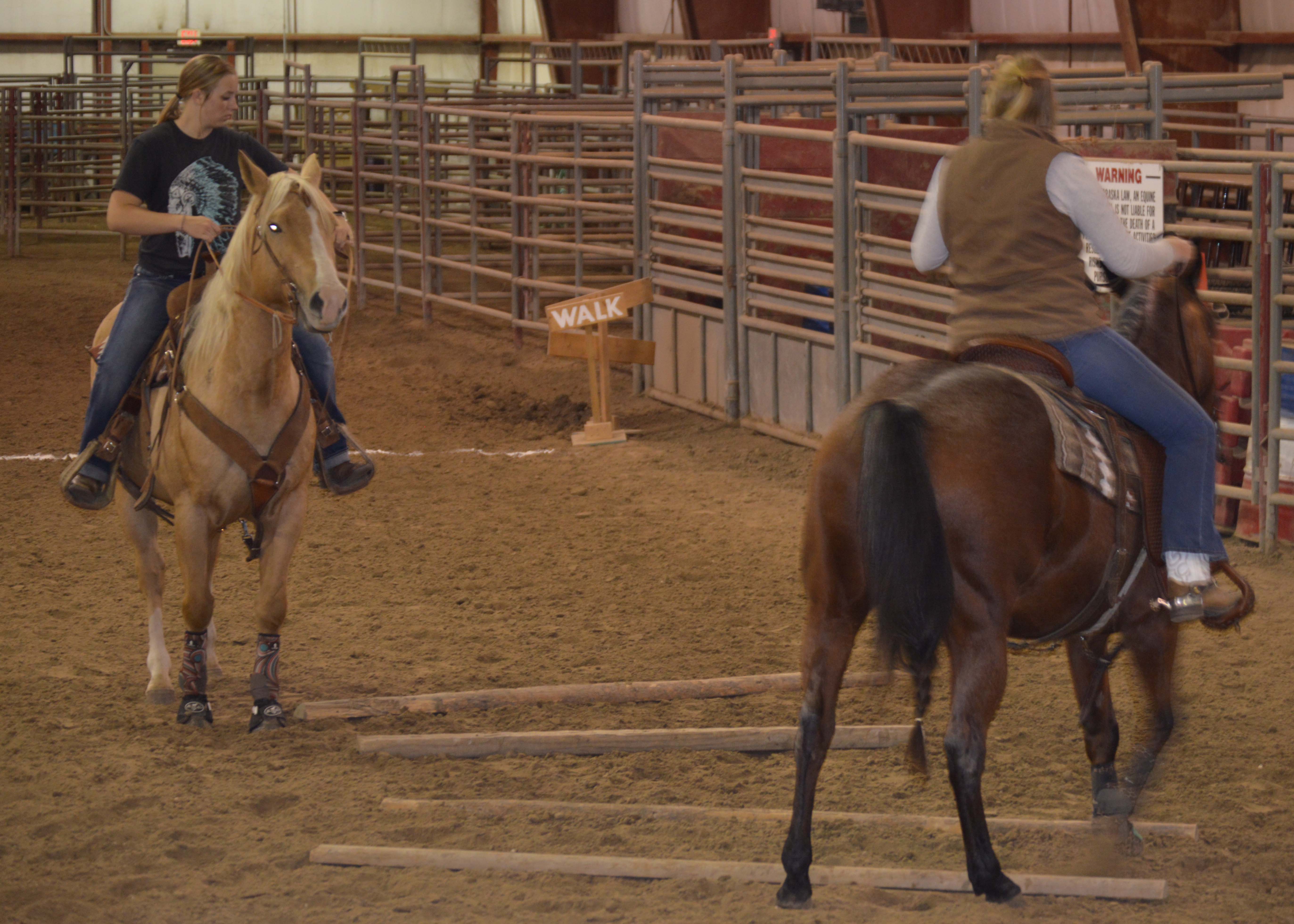 Annie Bassett (at left), NCTA Ranch Horse Team member from Ogallala, and her mare Annabelle gain pointers on how to side pass in a trail riding course with Huntra Christenson, assistant coach. (Crawford / NCTA photo) 