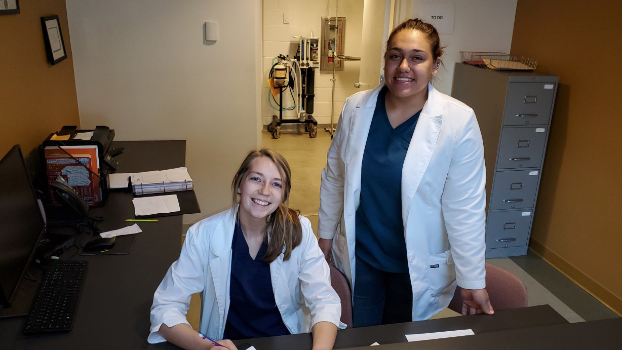 Now in the workforce, Joli Brown of Waverly (seated) and Chloe Herrera of Alliance graduated May 7. In February, they were finishing their clinical rotation at the Dr. Walter Long Veterinary Technology Teaching Clinic at the NCTA campus. (Photo by M. Crawford / NCTA)