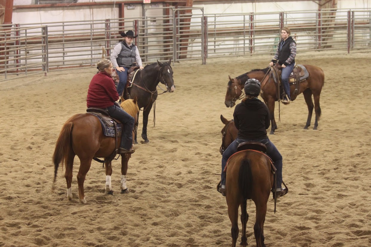 Professor Joanna Hergenreder meets with members of the NCTA Ranch Horse Team during a practice session in the indoor arena of Livestock Teaching Center on campus.  (Emily Grote photo / NCTA News