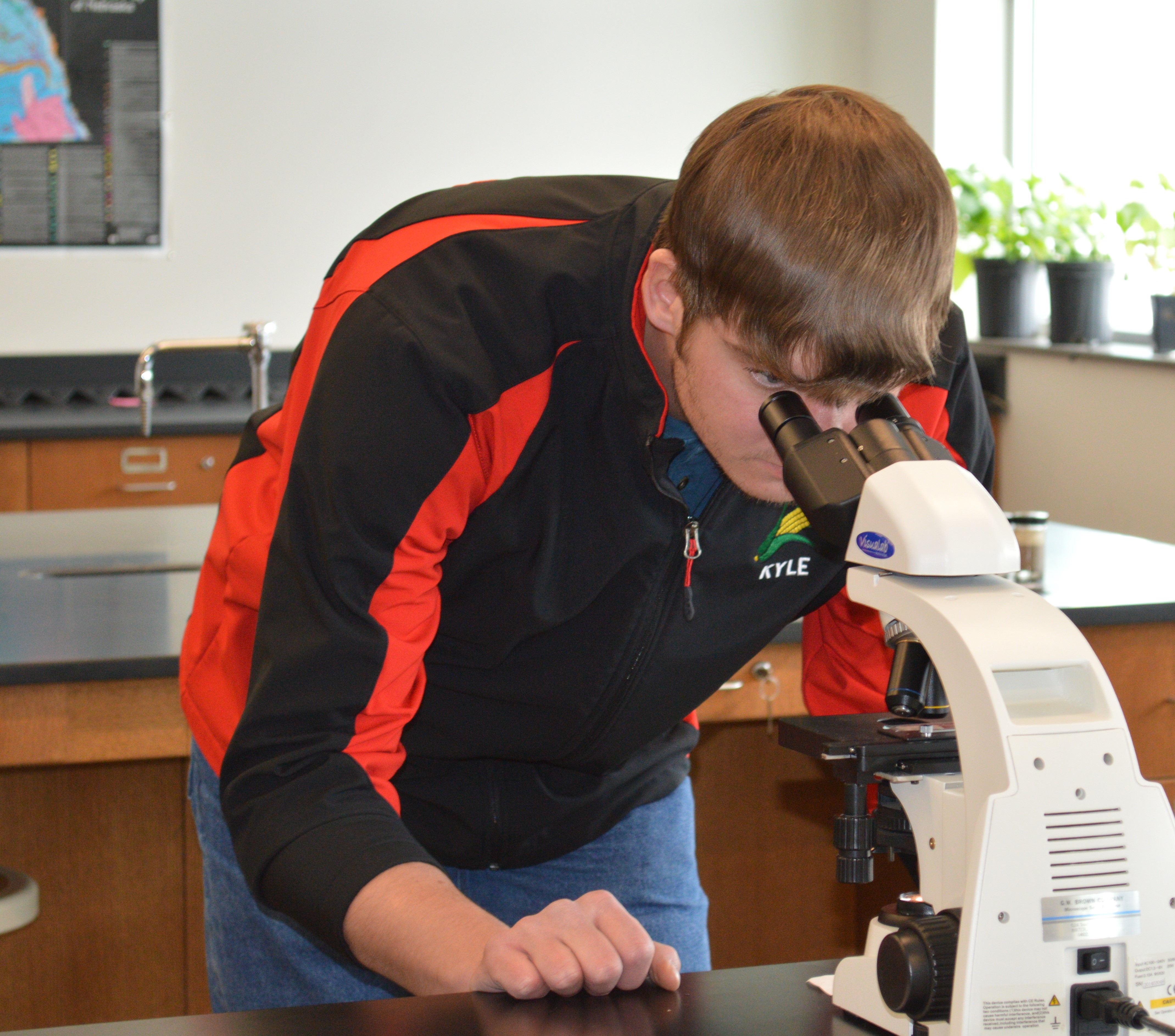 Kyle Krantz of Alliance examines plant tissue in the NCTA crops lab. (T. Smith / NCTA photo)