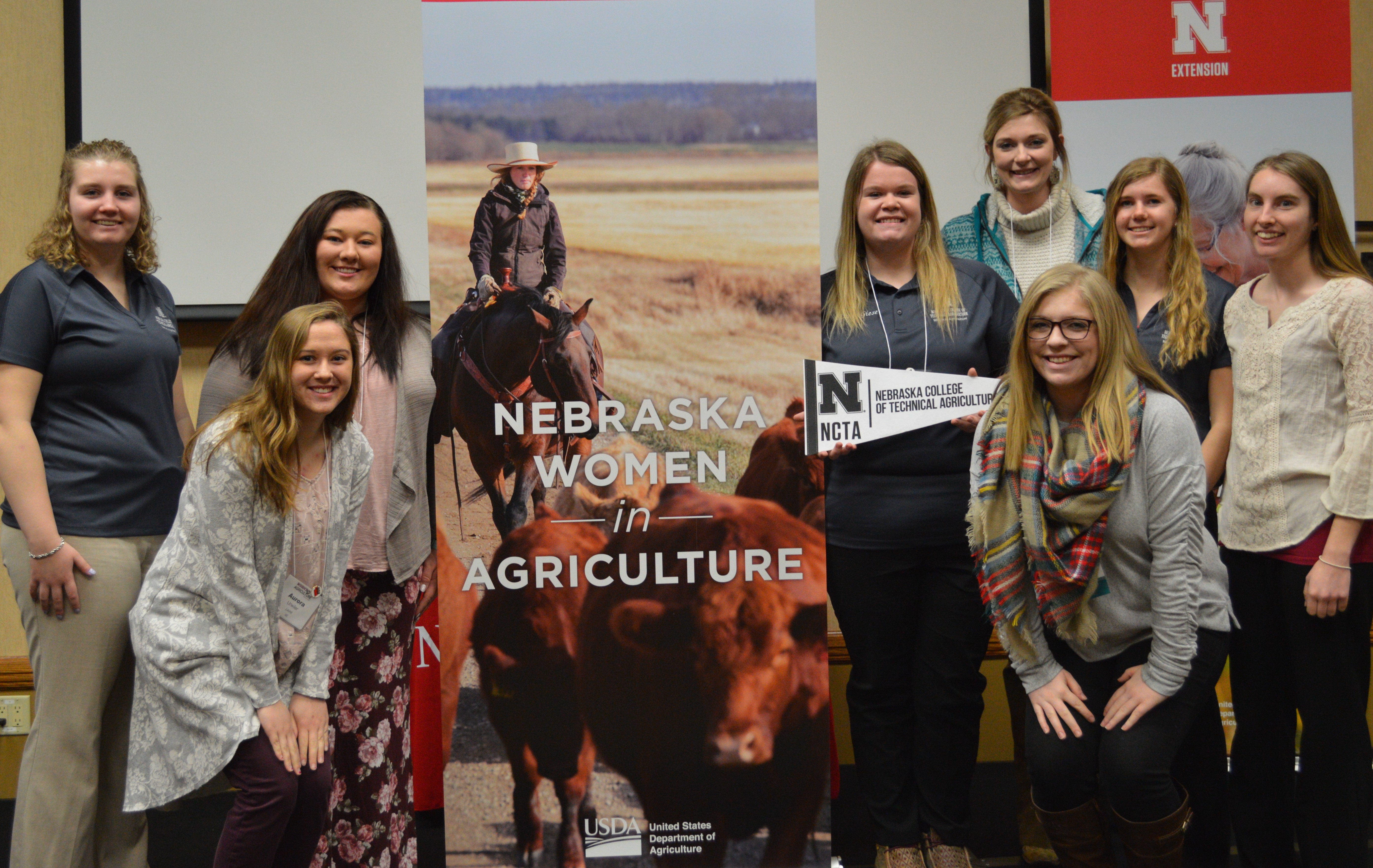 Aggie students from the Nebraska College of Technical Agriculture who attended the Nebraska Women in Ag conference Feb. 21-22 in Kearney were, (left side of poster) Chantelle Schulz, Aurora Urwiler and Kayla Mues, and (right of poster) Jocelyn Kennicutt, front, Emily Giese holding pennant, Assistant Professor Meredith Cable, Tiffany Dickau, and Catherine Ljunggren. (J. Kroeger / NCTA Photo)