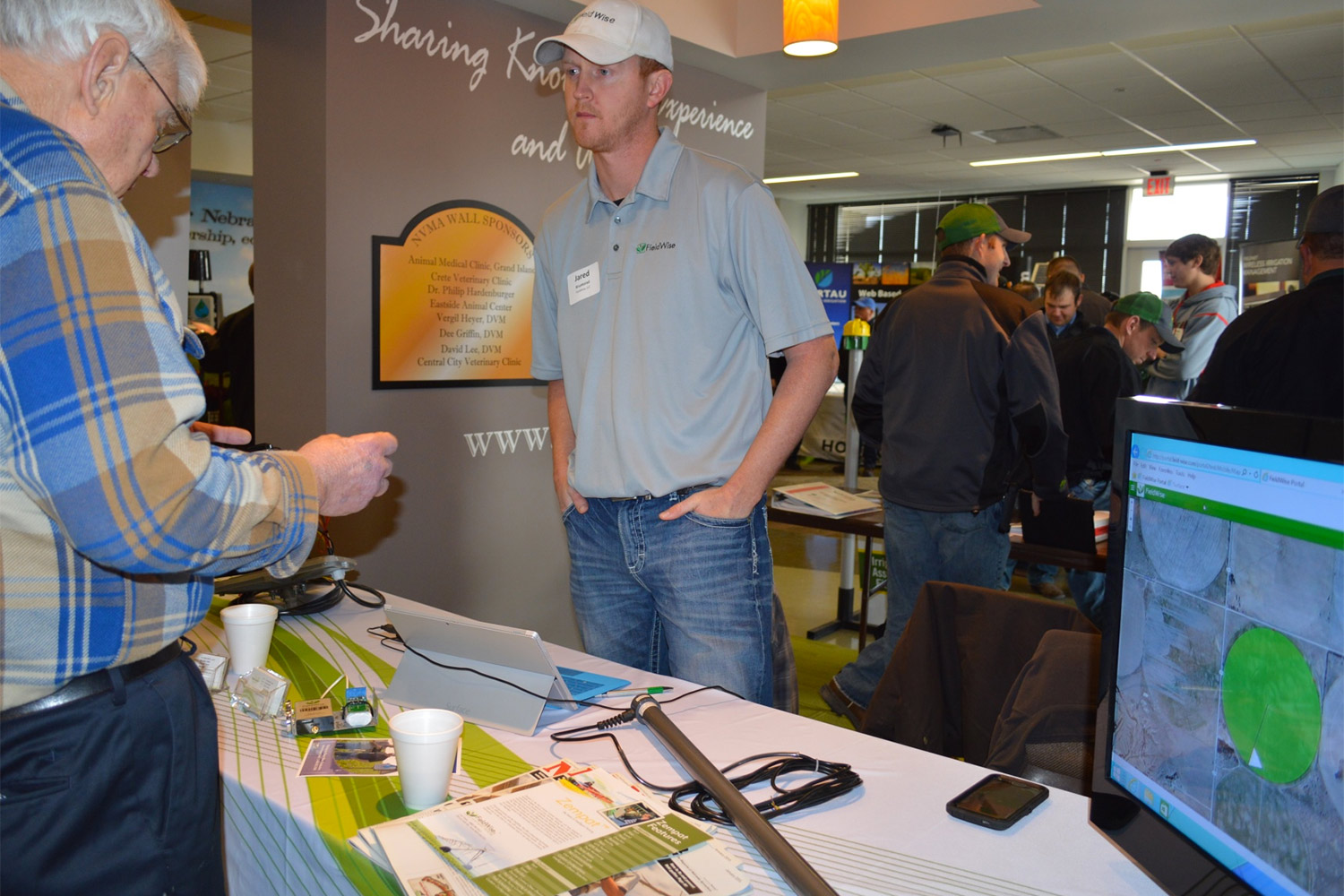 Ted Tietjen of Grant, Neb., discusses irrigation technology and tools with Jared Kruntorad, Ewing, Neb., sales manager of FieldWise LLC, during the 2015 irrigation management conference at NCTA in Curtis. (NCTA photo)