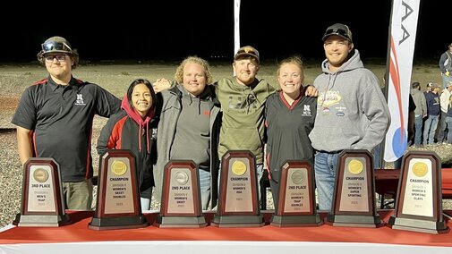 NCTA Shotgun Team members (L-R) Cody Flint, Herald, CA; Nathaly Dragoo, Lincoln (social media mgr); Maddy Carr, North Platte; Gavin Tremblay, Hoxie, KS; Emily Miller, Norton, KS; and Nolan Buss, Stockton, KS. (Jennifer Miller photo credit) Awards are sitting on a table and the students are behind the table.