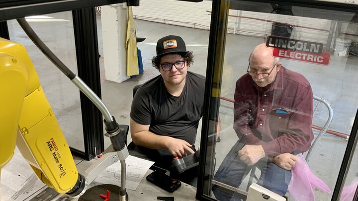 Cody Flint of Herald, CA, and Dan Stehlik, Ag Mechanics instructor, operating the Fanuc robotic welder.