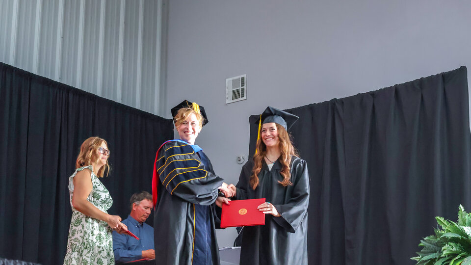 Student receiving diploma on graduation day. 