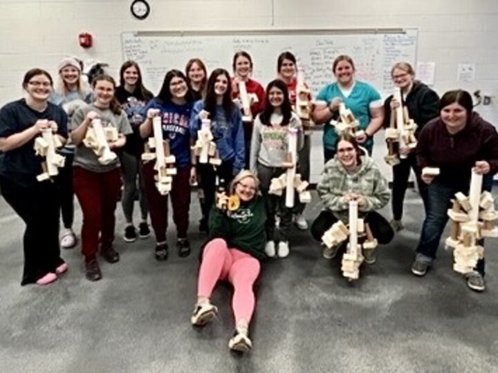 Vet Tech students pose with the reusable toys they invented for parrots. 