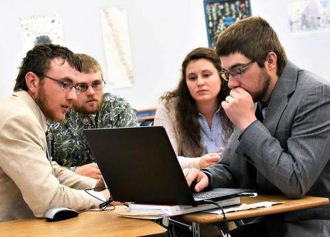 Cody Most, Riley Abbott, Erica Mowery and Nate Letcher of the NCTA Agribusiness Computer Team solve a problem at a national contest of agricultural college students. Abbott, Mowery and Letcher were third-year, double majors who graduated in May with academic honors. (Photo by Northeast Community College)  