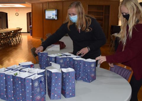 Annie Bassett and Addy Villwok, sophomores on the NCTA Ranch Horse Team, prepare gift bags for veterans. (R. Faber / NCTA photo)