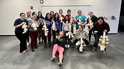 Vet Tech students pose with the reusable toys they invented for parrots. 