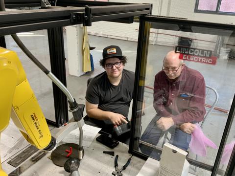 Cody Flint of Herald, CA, and Dan Stehlik, Ag Mechanics instructor, operating the Fanuc robotic welder.