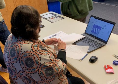 Professor Mary Rittenhouse assists with registration at the COVID-19 screening in January. (Gossen / NCTA Photo)