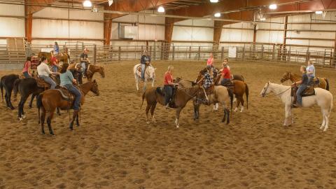 Ranch Horse Team and equine students meet with Coach Jo Hergenreder, center, at the Nebraska College of Technical Agriculture. They host the Punchy in Pink Spring Roundup April 8 to 10 in McCook for open class and college divisions. (George Hipple Photography / NCTA)