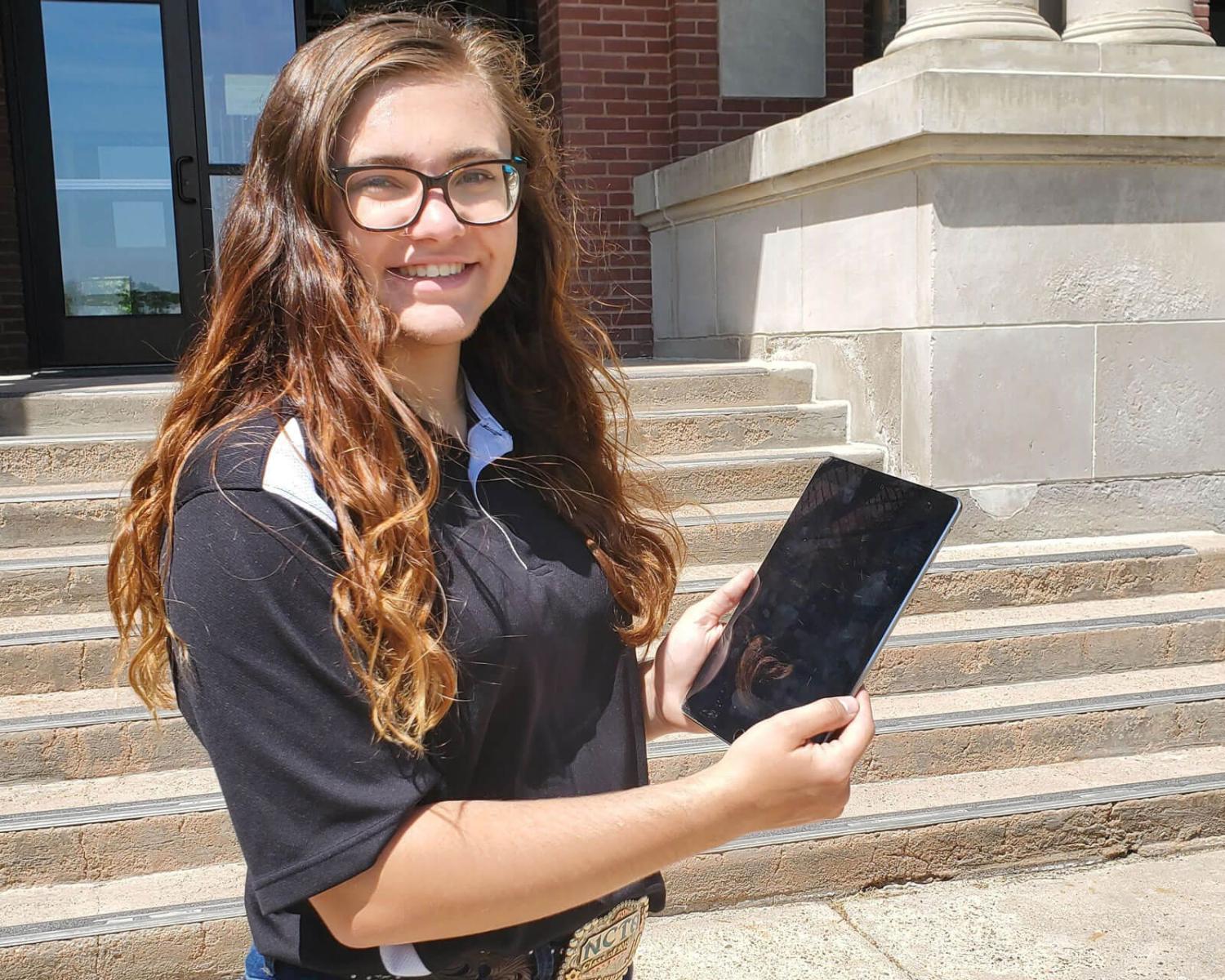A student holding an iPad.